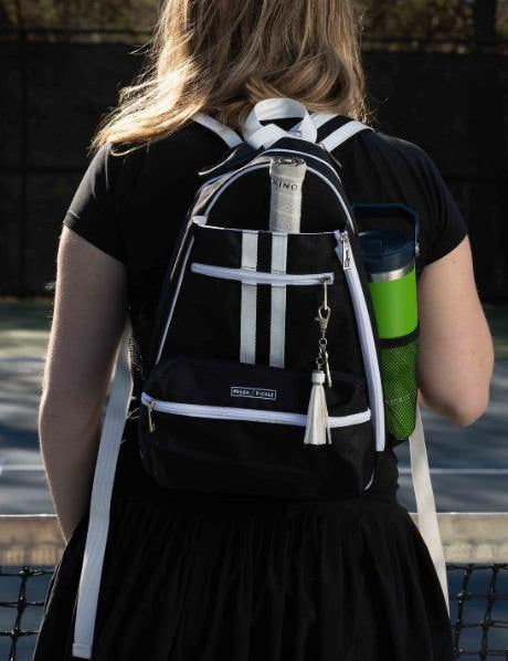 Woman wearing black pickleball backpack with water bottle and towel on outdoor court
