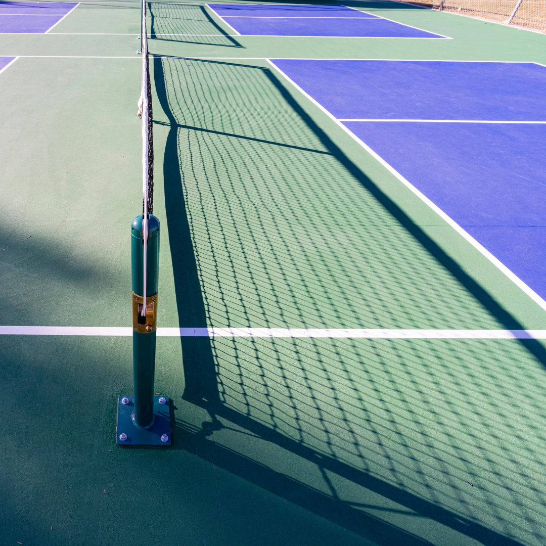 Outdoor pickleball court with net and vibrant blue and green court surface