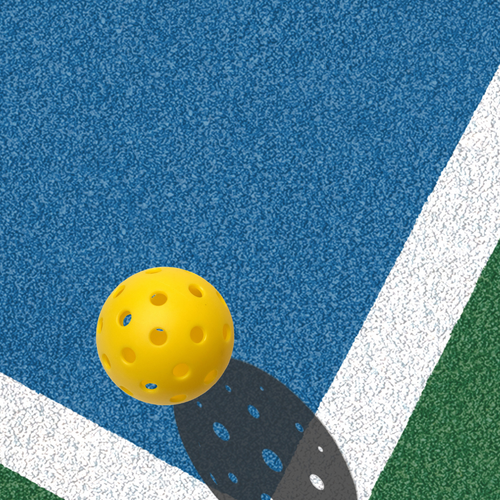 Yellow pickleball on blue and green court near white boundary lines