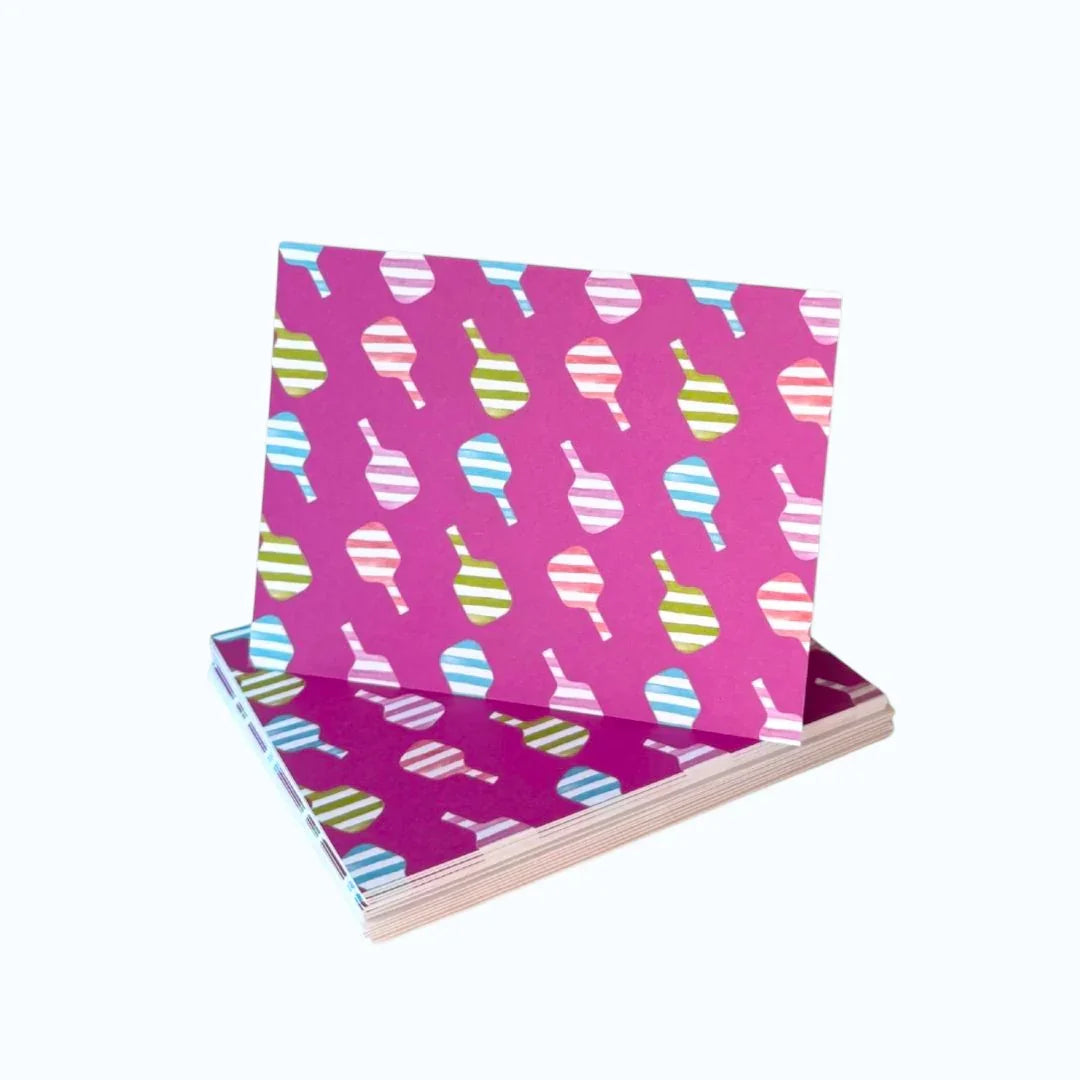 Pink greeting card with colorful striped pickleball paddle pattern